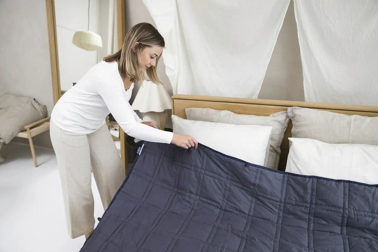 A bed being made up with fresh linen