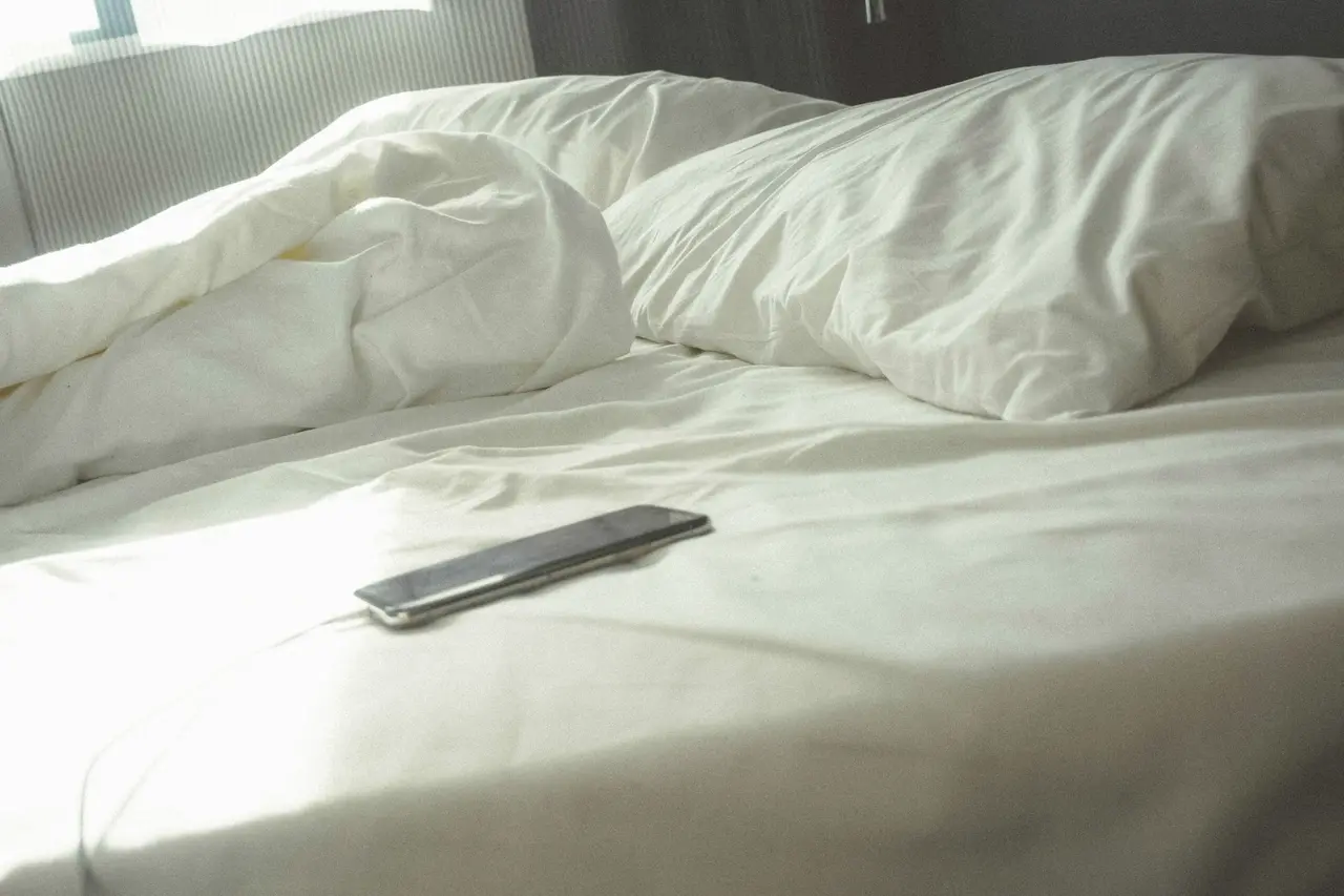 An unmade bed in morning light after a guest has checked out