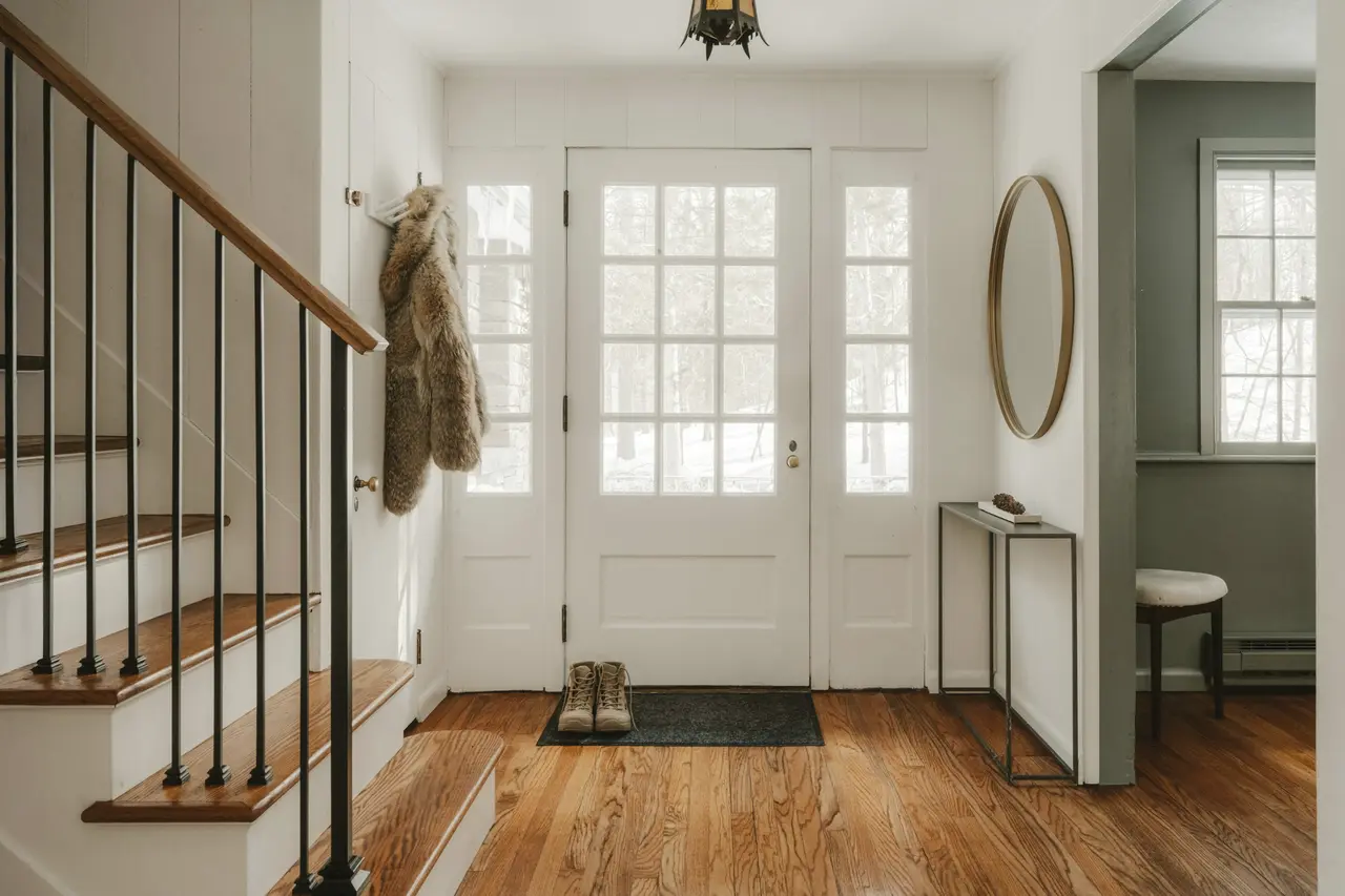 A bright entrance hall with a staircase and timber floors