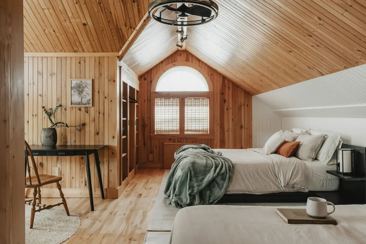 A timber-lined attic bedroom in a holiday home
