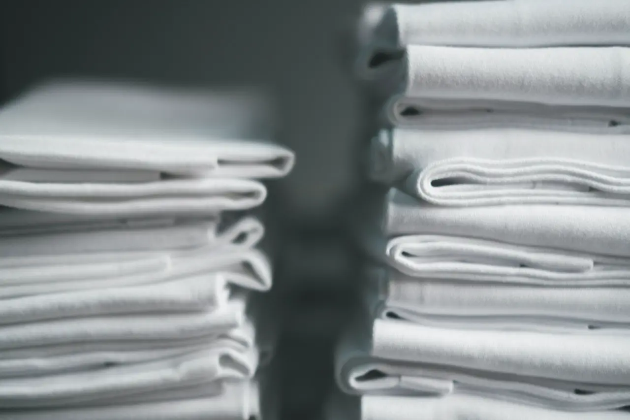 Stacks of freshly laundered and folded white sheets