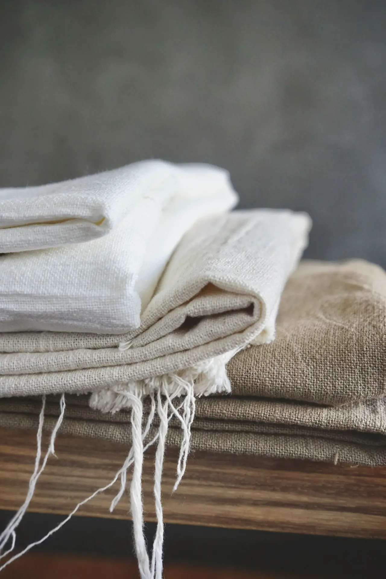 A stack of folded linen on a timber bench