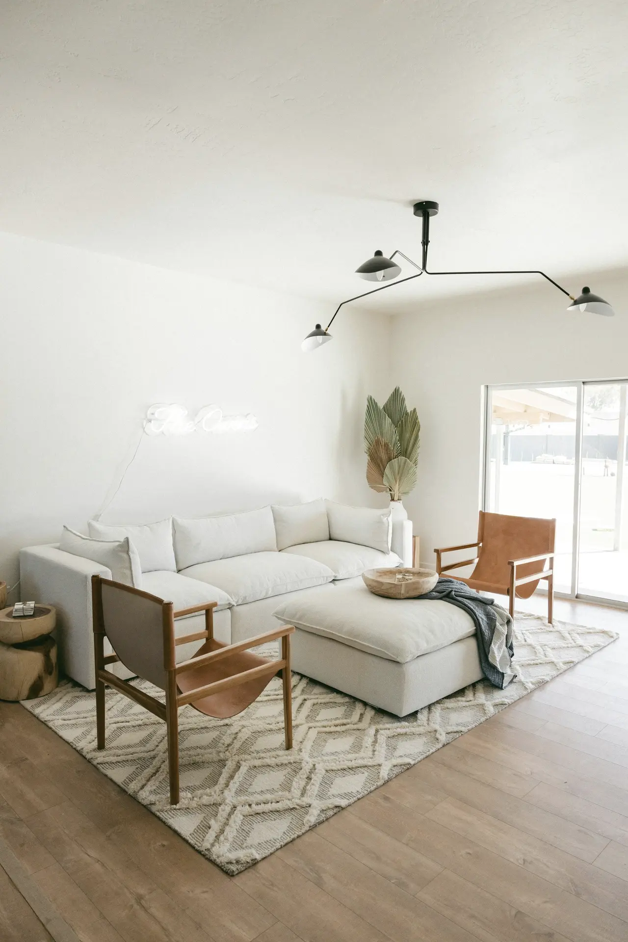 A living room with a patterned rug, white sofa and timber floors
