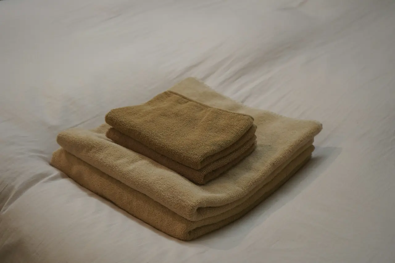 Folded towels set out on a freshly made bed