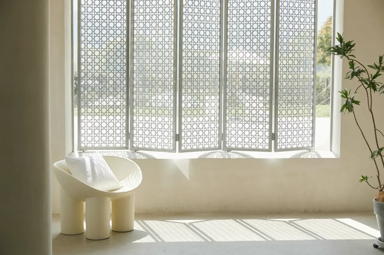 Sunlight through a large window onto a white chair